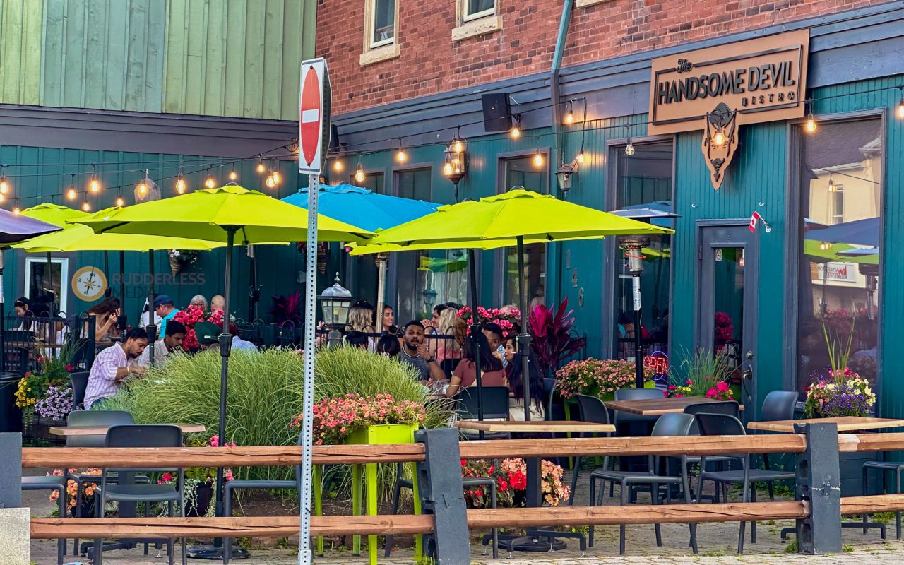 elora - a group of people sitting at tables outside a restaurant