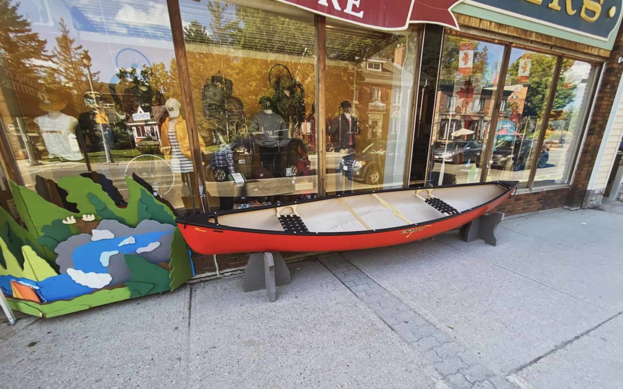 a red canoe on display in front of a retail store