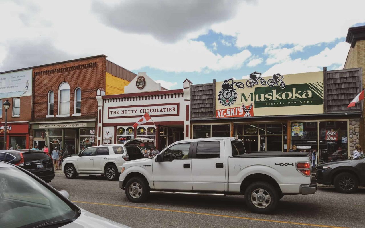 a view of Huntsville's downtown, showing the storefronts of The Nutty Chocolatier and Muskoka Bicycle Pro Shop