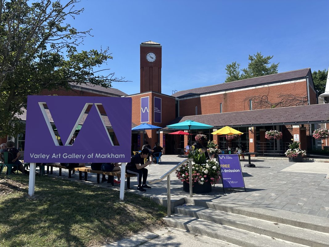 a building with a sign and umbrellas