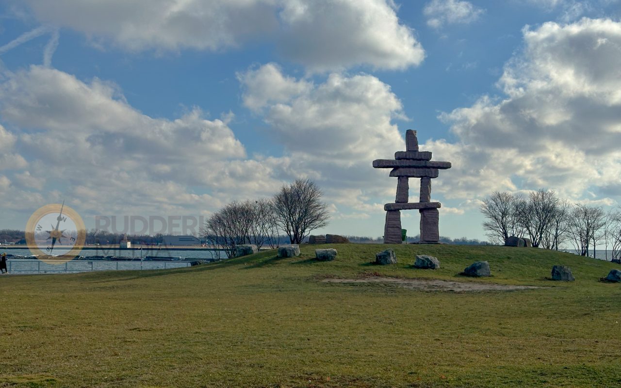 a large stone sculpture in the shape of a cross on a grassy hill - martin goodman trail