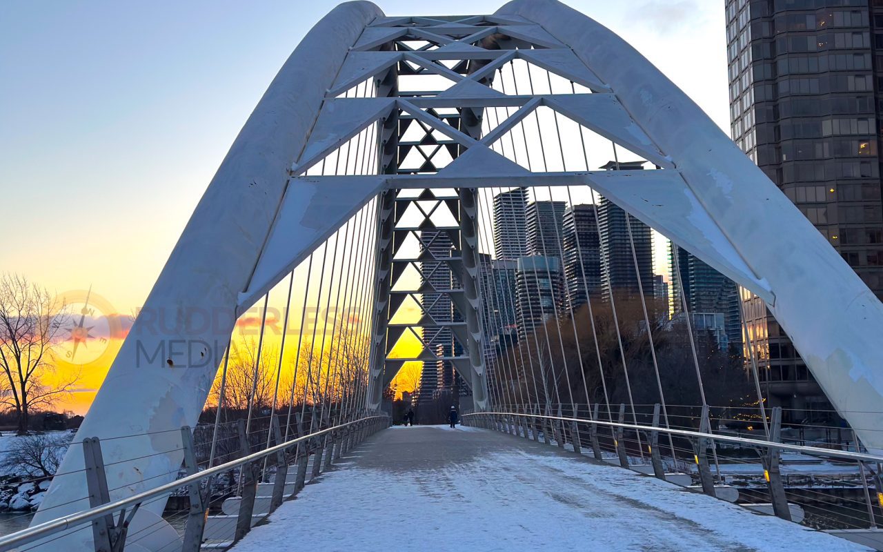 a bridge with snow and a city in the background