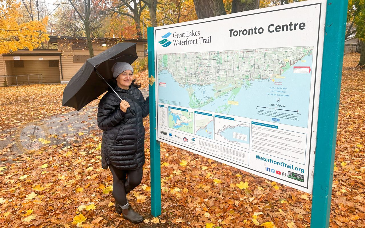 a woman standing next to a sign with an umbrella - martin goodman trail map