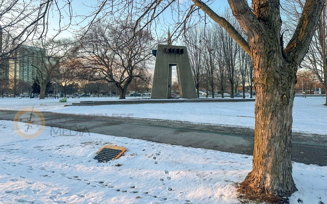 a large stone structure with a bell tower in the middle of a snowy park