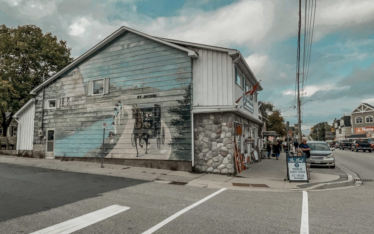 large mural of a horse-drawn carriage on the side of a building | st jacobs attractions