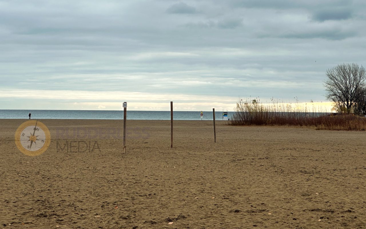 a beach with poles in the sand - toronto lakefront