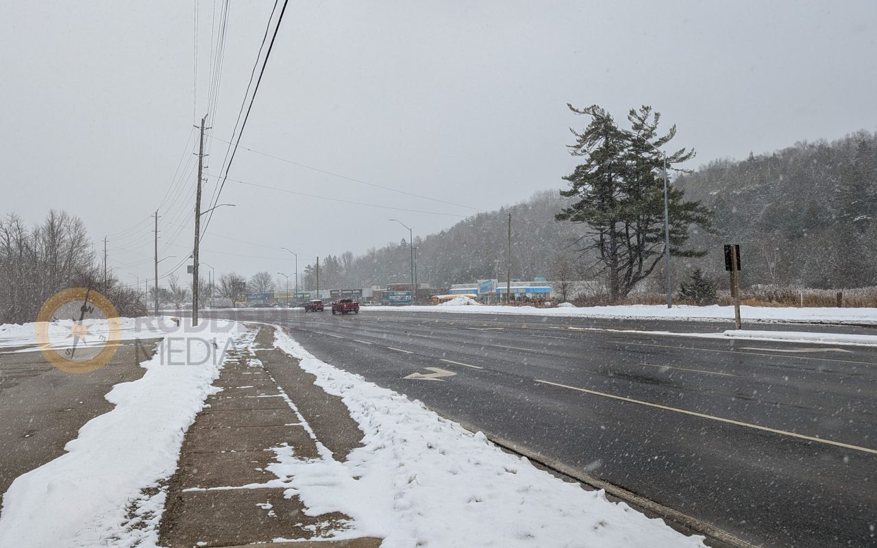 a road with snow on it - winter car safety kit