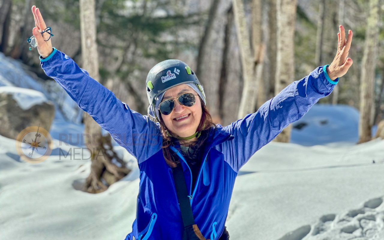 a woman wearing a helmet and sunglasses with her arms up in the air - winter road trip from toronto-1